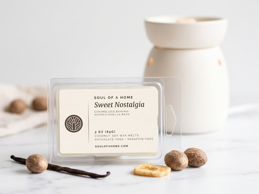 A packaged wax melt product labeled 'Sweet Nostalgia' by Soul of a Home, placed on a light marble surface with vanilla beans, nutmegs, and a cream-colored wax warmer in the background.
